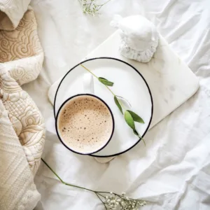 A steaming cup of French vanilla coffee in a white mug with vanilla beans and a spoon on the side.